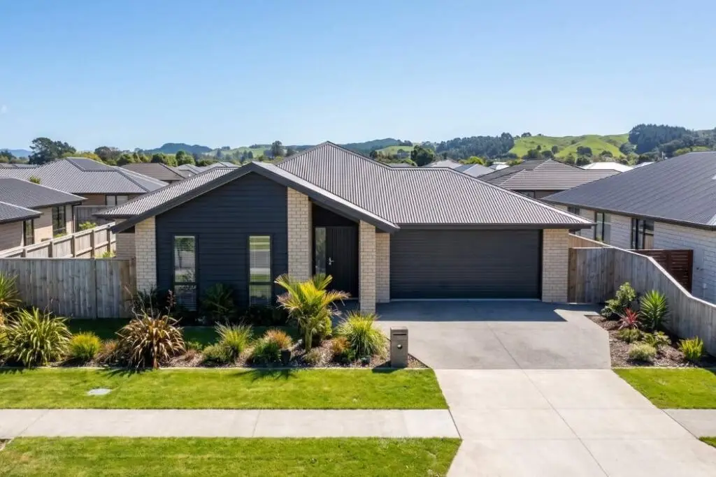 A modern brick and weatherboard New Zealand family home with rolling hills behind it