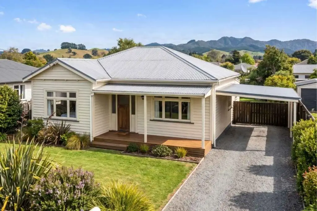 A white weatherboard New Zealand home with hills behind it, the kind of first home a 5% deposit can buy